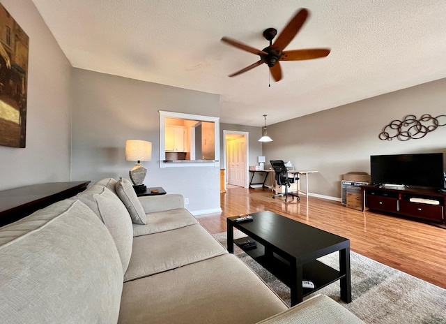 living room featuring a textured ceiling, hardwood / wood-style floors, and ceiling fan