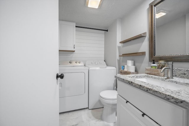 bathroom featuring separate washer and dryer, vanity, a textured ceiling, and toilet