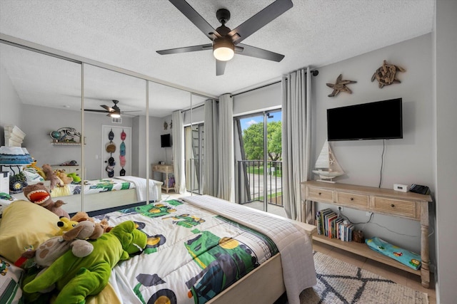 bedroom featuring a textured ceiling, tile patterned flooring, a closet, ceiling fan, and access to exterior