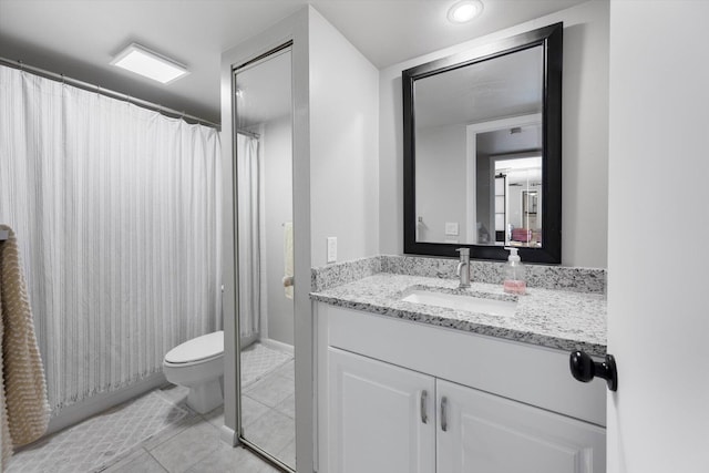 bathroom with toilet, tile patterned flooring, and vanity