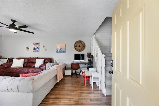 living room featuring a textured ceiling, ceiling fan, and dark hardwood / wood-style floors