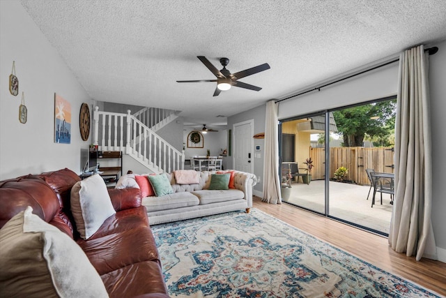 living room featuring a textured ceiling, ceiling fan, and hardwood / wood-style flooring