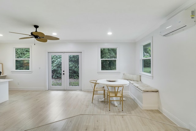 unfurnished dining area with light wood-style floors, french doors, crown molding, and a wall mounted air conditioner