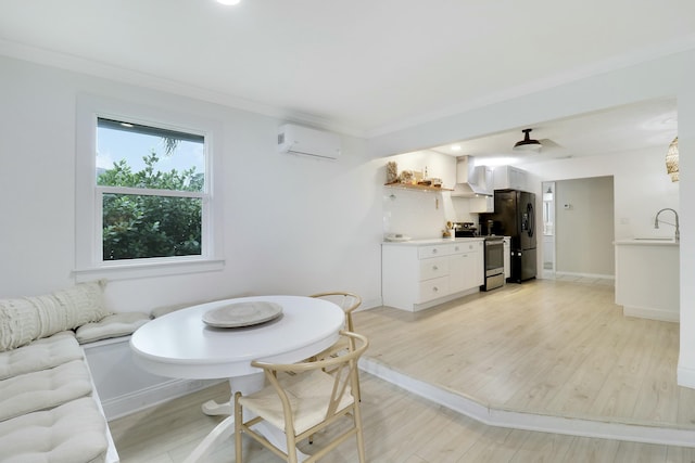 dining space with light wood finished floors, baseboards, ornamental molding, and a wall mounted AC