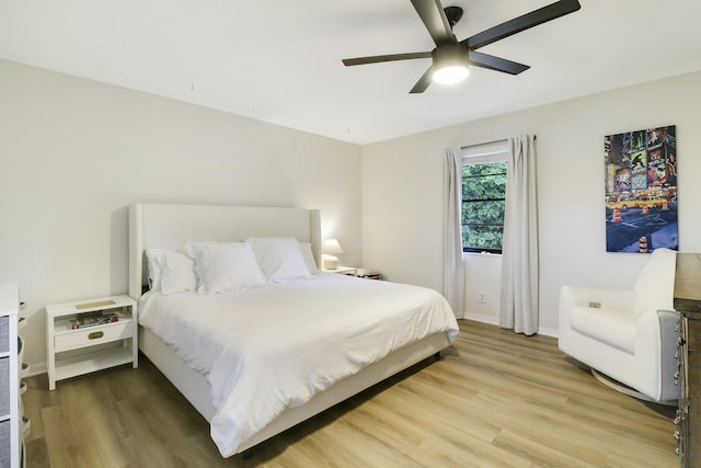 bedroom with wood finished floors, a ceiling fan, and baseboards