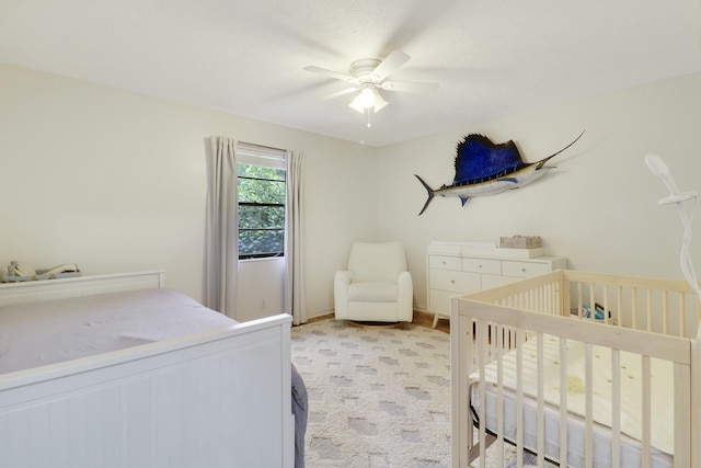 bedroom featuring a crib and a ceiling fan