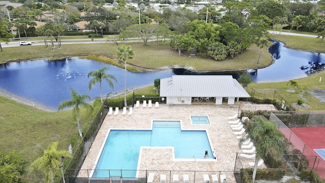 pool featuring a water view, a patio area, and fence