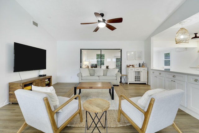 living room featuring light wood-type flooring, a wealth of natural light, and visible vents