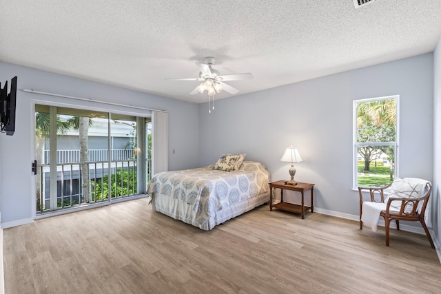 bedroom with ceiling fan, light hardwood / wood-style floors, access to outside, and multiple windows