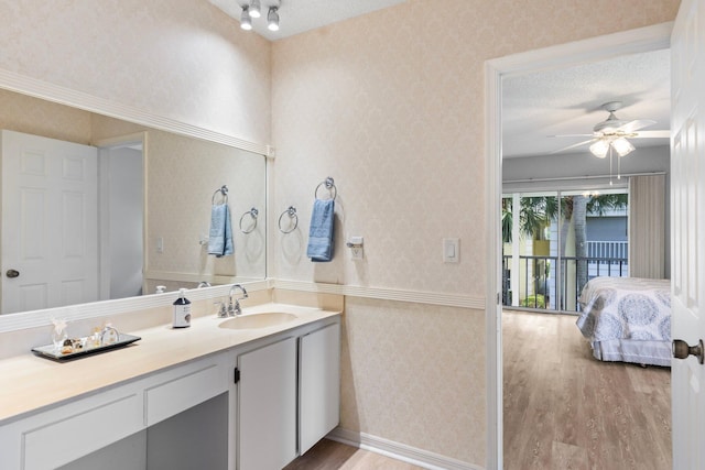 bathroom featuring hardwood / wood-style flooring, a textured ceiling, ceiling fan, and vanity