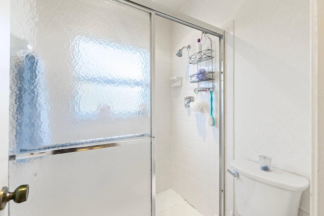 bathroom featuring toilet and an enclosed shower