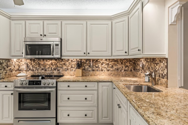 kitchen featuring sink, white cabinets, backsplash, and appliances with stainless steel finishes