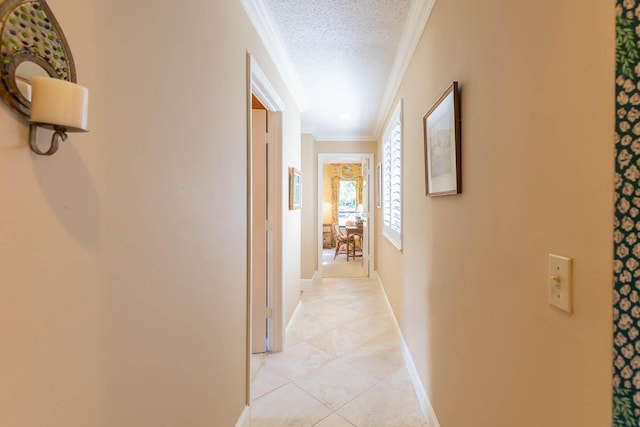 hallway featuring ornamental molding, light tile patterned flooring, and a textured ceiling