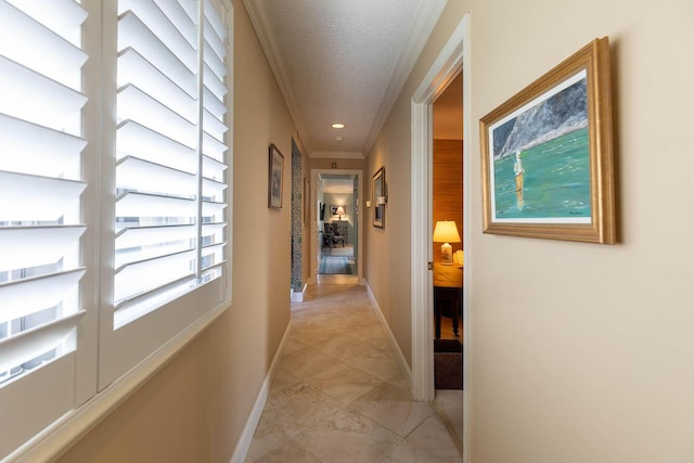 hall with ornamental molding and a textured ceiling