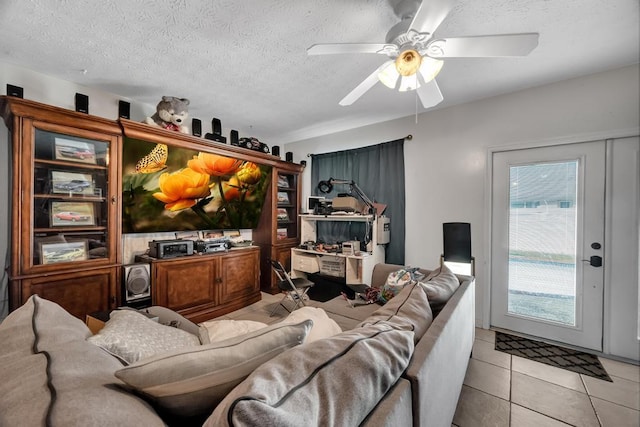 living room featuring light tile patterned floors, a textured ceiling, and ceiling fan