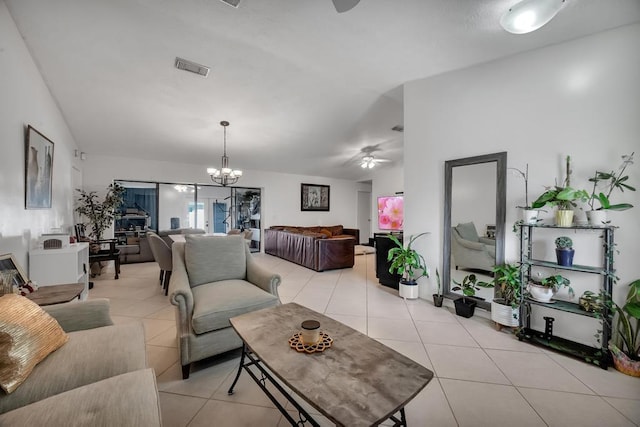 living room with light tile patterned flooring, lofted ceiling, and ceiling fan with notable chandelier