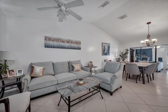 living room featuring lofted ceiling, light tile patterned floors, and ceiling fan with notable chandelier