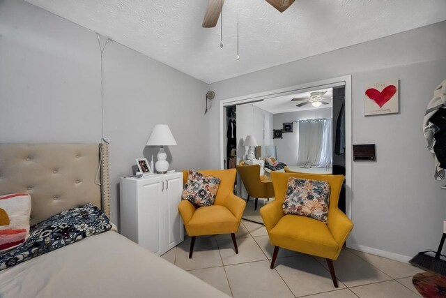 tiled bedroom with a textured ceiling, a closet, and ceiling fan