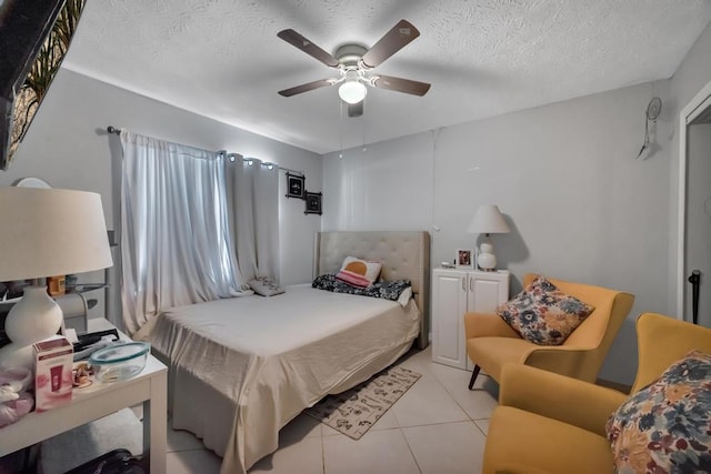 tiled bedroom featuring ceiling fan and a textured ceiling