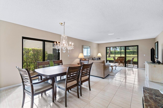 dining space with a textured ceiling, a notable chandelier, and light tile patterned floors