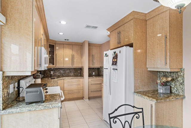 kitchen featuring white appliances, light tile patterned flooring, backsplash, and light stone counters