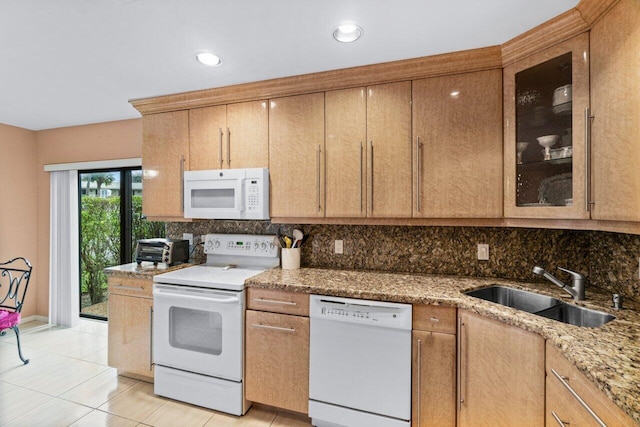 kitchen with white appliances, stone counters, decorative backsplash, sink, and light tile patterned flooring