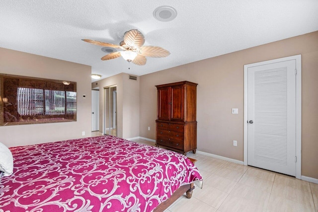 bedroom with ceiling fan and a textured ceiling