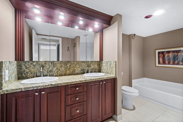 bathroom with toilet, vanity, and decorative backsplash