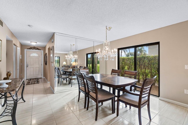 dining area with a textured ceiling, light tile patterned floors, and a chandelier