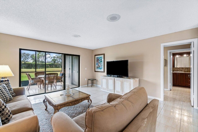 tiled living room featuring a textured ceiling