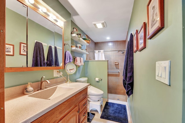 bathroom featuring tiled shower, vanity, and toilet