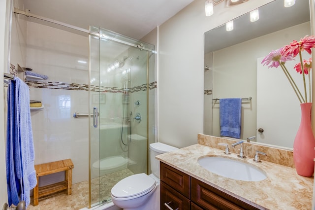 bathroom with an enclosed shower, vanity, and toilet