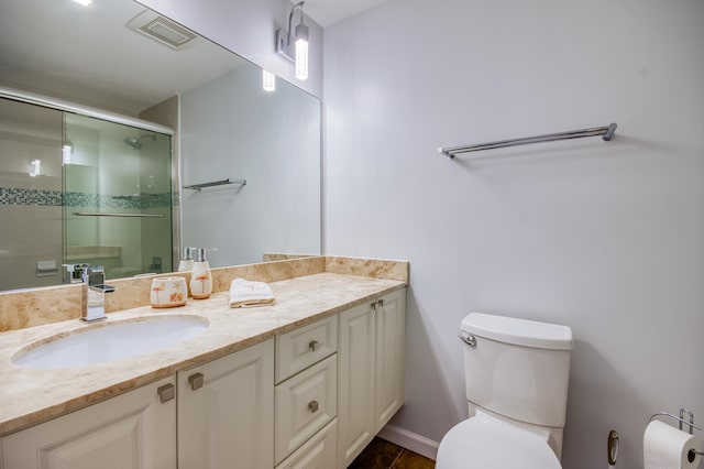 bathroom with vanity, toilet, and an enclosed shower