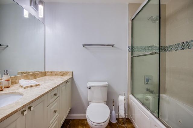 full bathroom featuring vanity, tile patterned flooring, combined bath / shower with glass door, and toilet