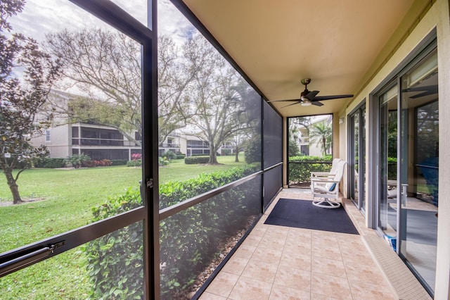 unfurnished sunroom featuring ceiling fan