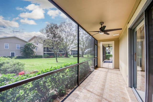 unfurnished sunroom with lofted ceiling, a healthy amount of sunlight, and ceiling fan