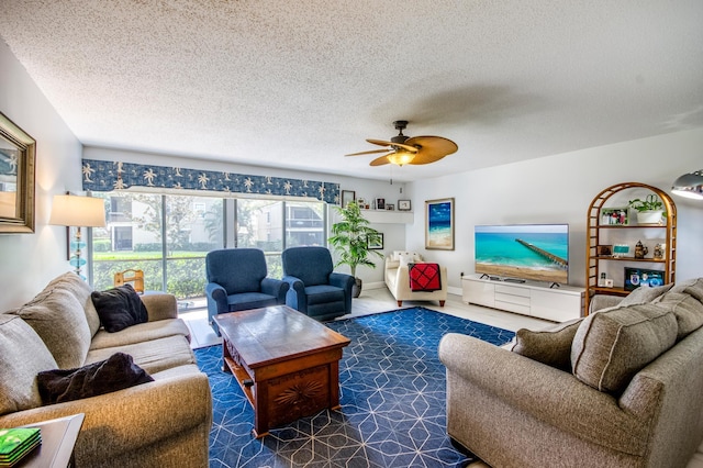 living room with ceiling fan and a textured ceiling