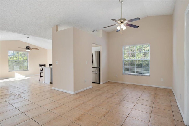 tiled spare room with ceiling fan, lofted ceiling, and a textured ceiling