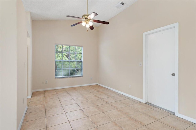 tiled spare room with lofted ceiling, ceiling fan, and a textured ceiling