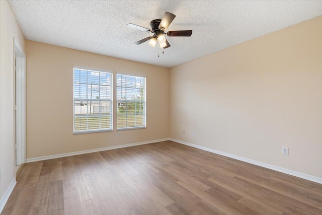 unfurnished room with ceiling fan, light hardwood / wood-style flooring, and a textured ceiling