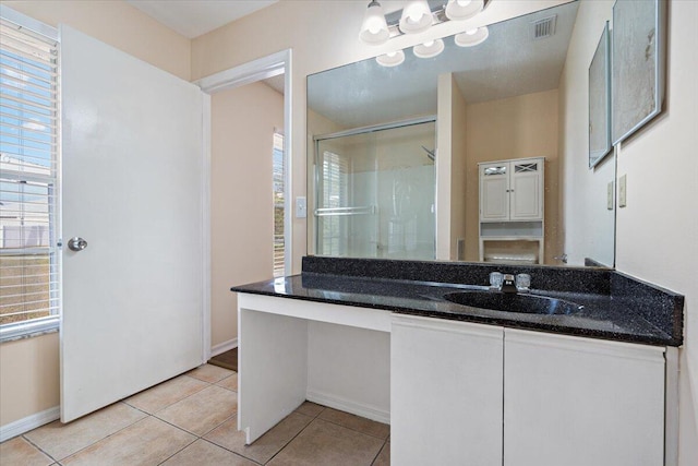 bathroom featuring vanity, tile patterned floors, and a shower with door