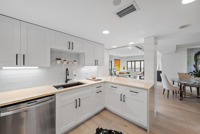 kitchen with dishwasher, white cabinetry, sink, kitchen peninsula, and light hardwood / wood-style flooring