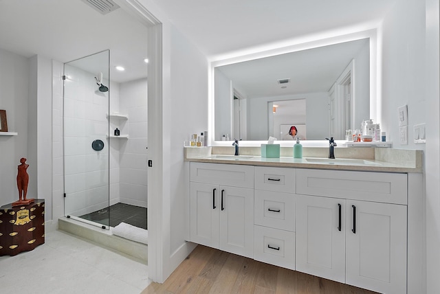 bathroom featuring vanity, tiled shower, and hardwood / wood-style flooring