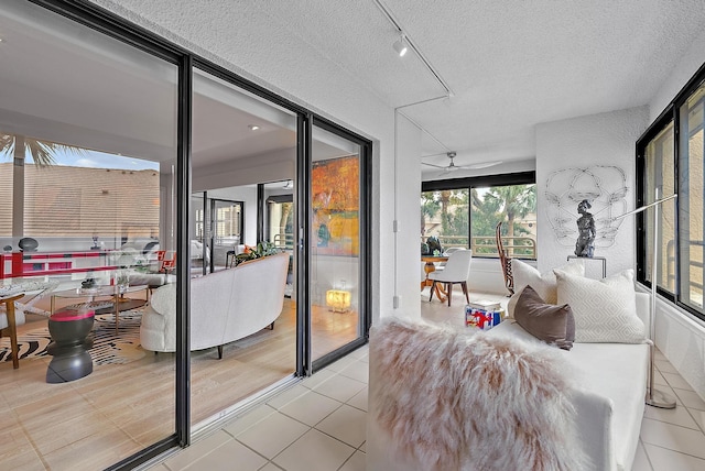 bedroom with rail lighting, a textured ceiling, and light tile patterned floors