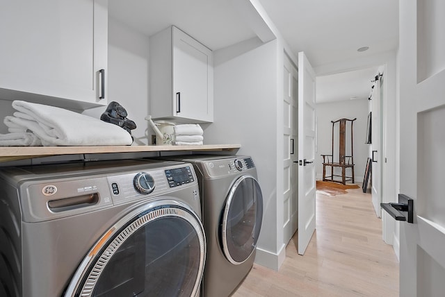 washroom featuring light hardwood / wood-style floors, cabinets, and washing machine and dryer