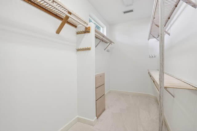 walk in closet featuring light colored carpet