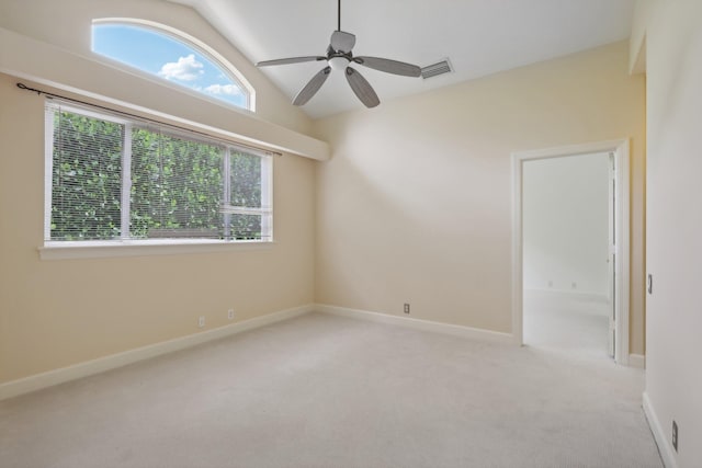 spare room featuring ceiling fan, vaulted ceiling, and light carpet