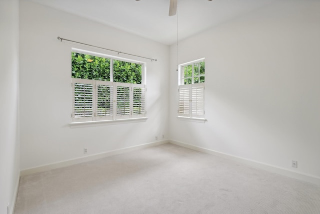 carpeted spare room with ceiling fan