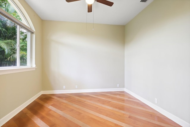 spare room featuring hardwood / wood-style flooring, ceiling fan, and a wealth of natural light