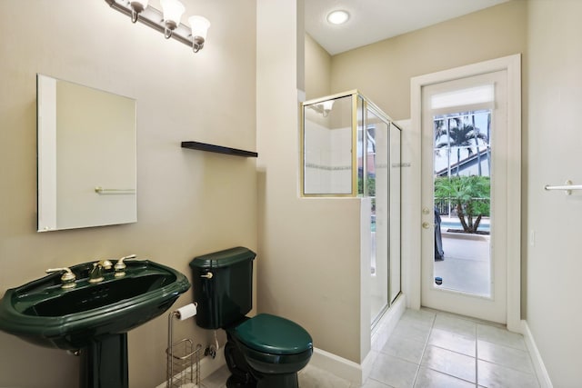 bathroom with toilet, walk in shower, and tile patterned floors